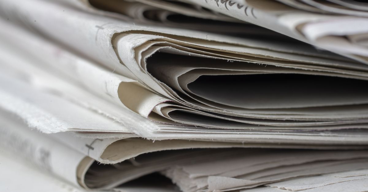 A detailed close-up view of stacked newspapers, highlighting textures and layers.